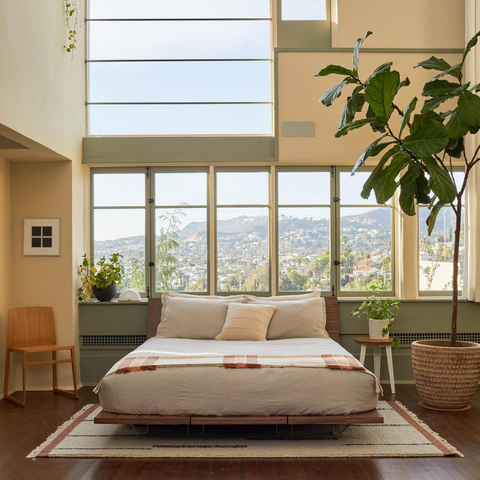 Budget-friendly wood plank bed with floating shelves in a modern, minimalist bedroom setting.